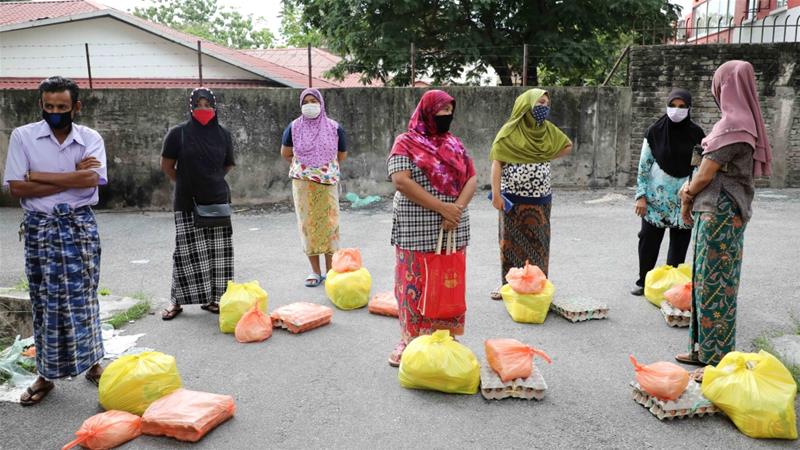 Rohingya refugees wearing protective masks keep distance from each other while waiting to receive goods from volunteers in Kuala Lumpur Malaysia on April 7 2020