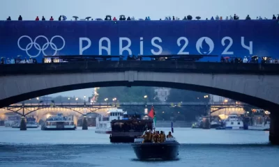 Paris 2024 Olympics – Opening Ceremony – Paris, Paris, France – July 26, 2024. The delegation of Vanuatu is seen passing under a bridge aboard a boat in the floating parade on the river Seine during the opening ceremony. (Photo by Clodagh Kilcoyne / POOL / AFP)